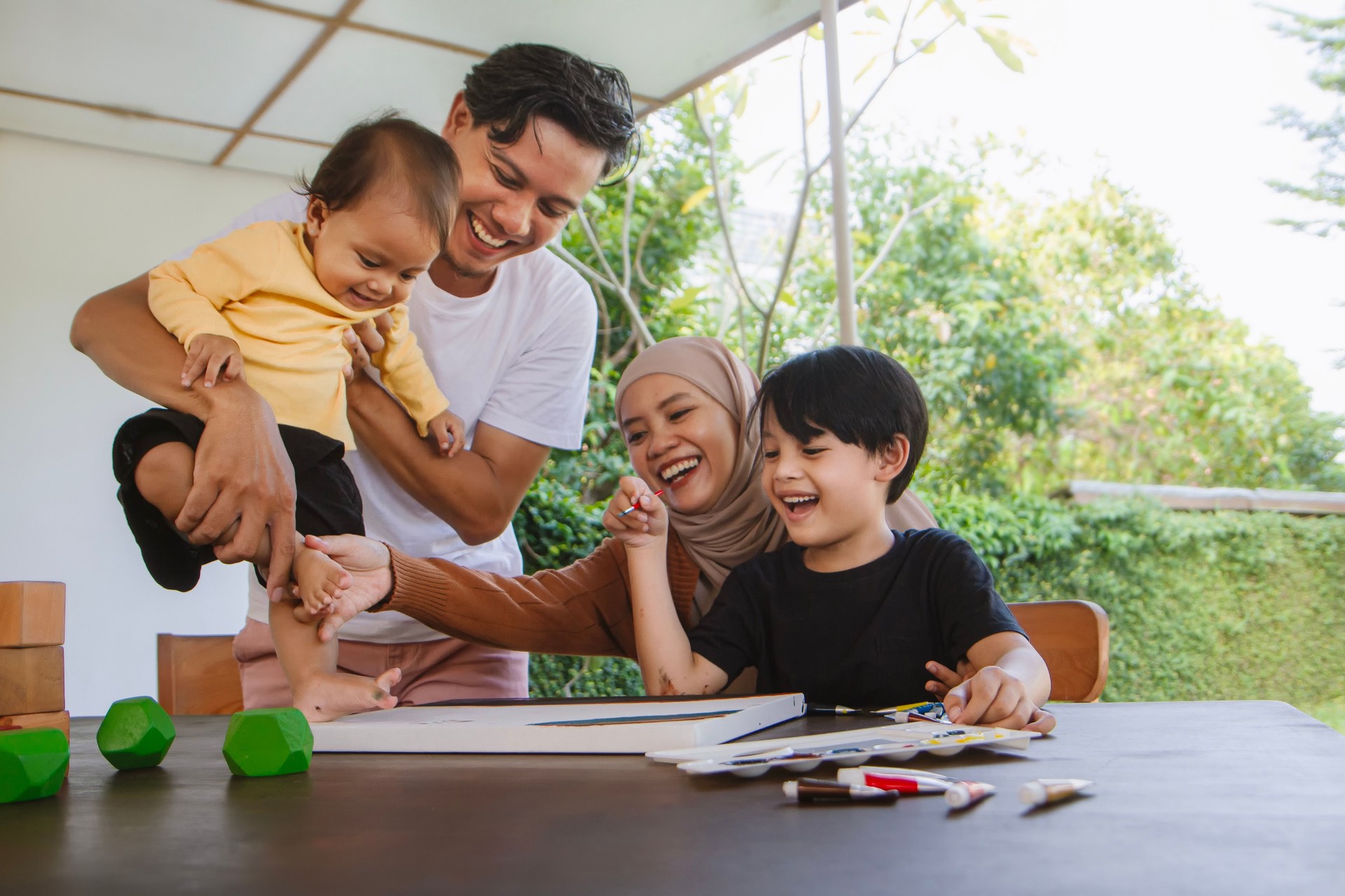 Happy asian muslim family. Parent teaching their children about crafting and painting